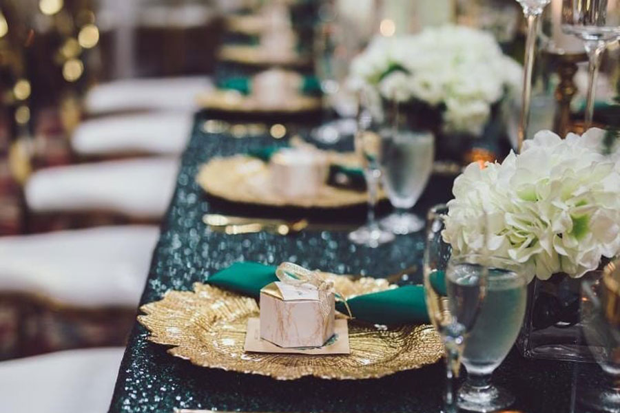 decorative table setting for event with gold and green accents